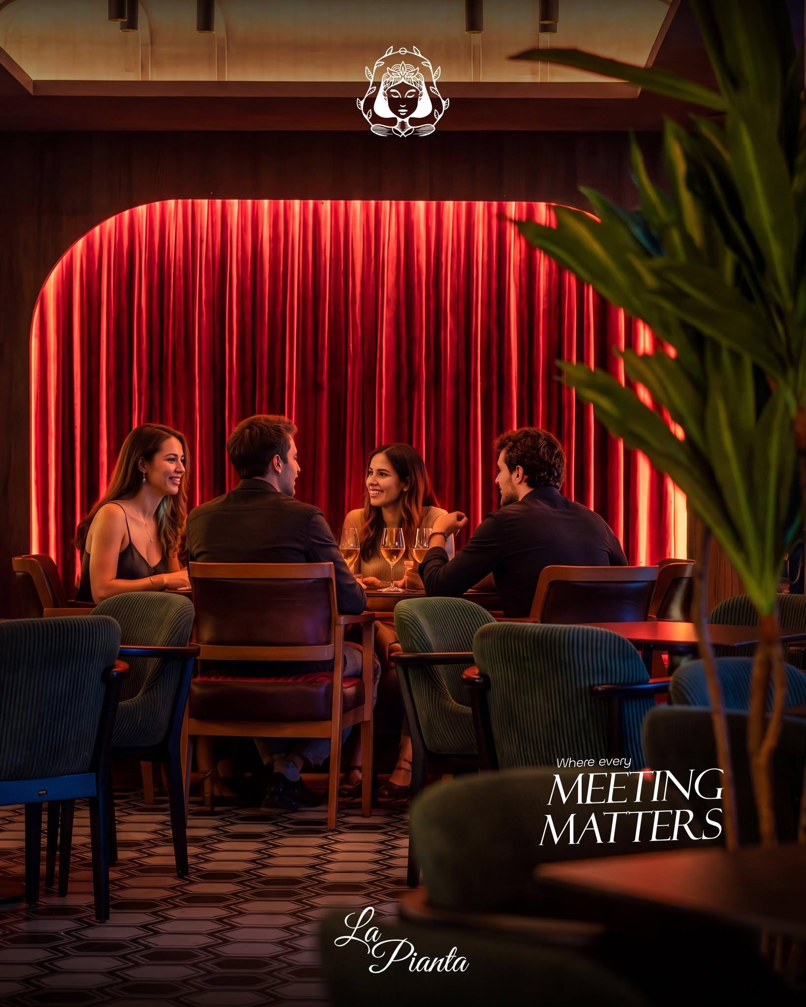 Four guests share a table in front of red curtains at La Pianta.