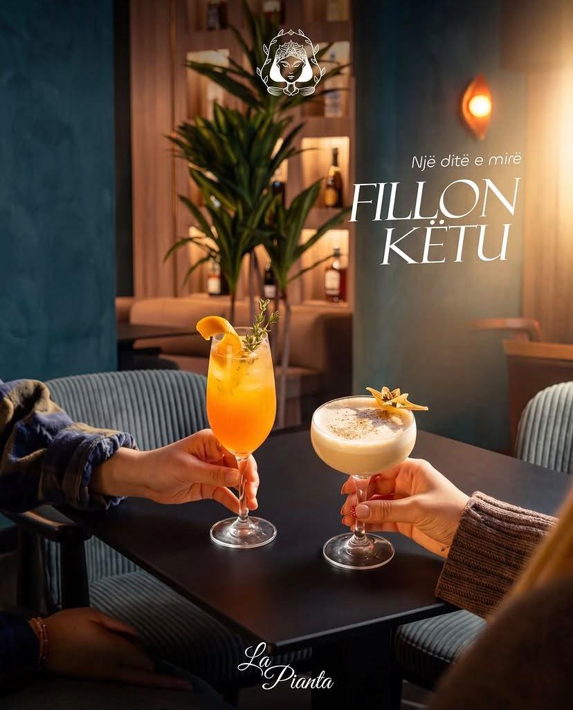 Two guests toast cocktails at a table inside La Pianta.